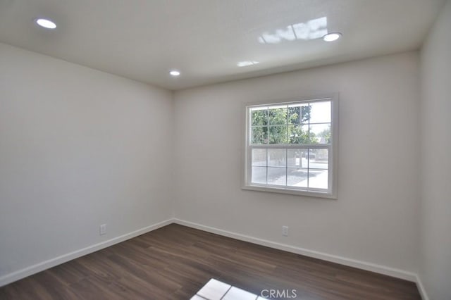 unfurnished room with dark wood-type flooring