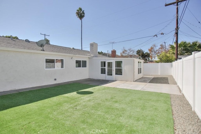 rear view of house with a lawn and a patio