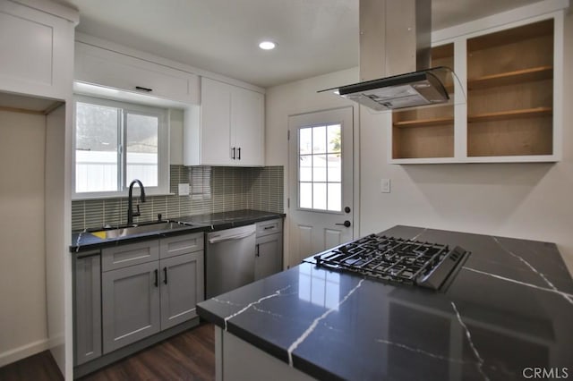 kitchen featuring appliances with stainless steel finishes, dark hardwood / wood-style flooring, tasteful backsplash, island range hood, and sink