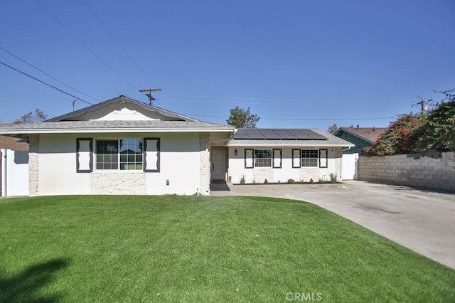 view of front of house featuring solar panels and a front lawn