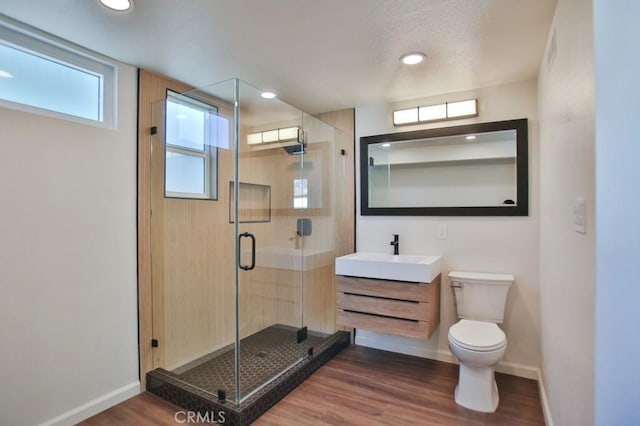 bathroom with vanity, wood-type flooring, an enclosed shower, and toilet