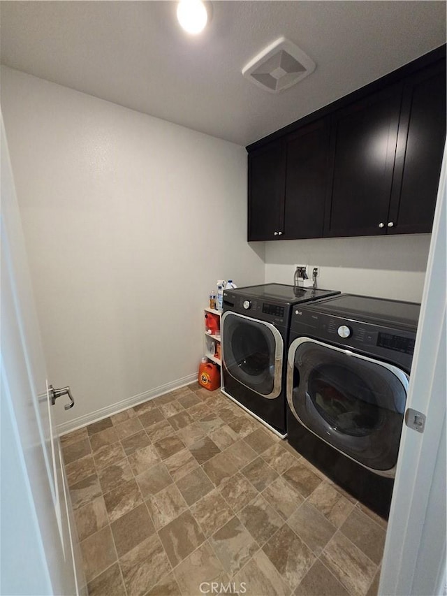 laundry area featuring separate washer and dryer and cabinets