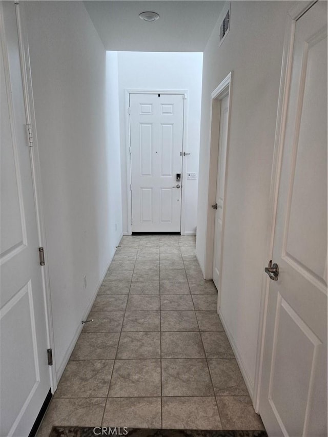 hall with light tile patterned floors