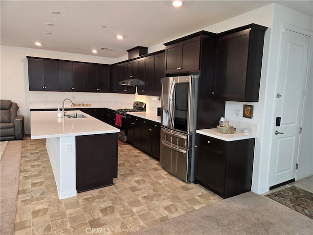 kitchen featuring stainless steel refrigerator with ice dispenser, sink, a kitchen island with sink, and black range with gas cooktop