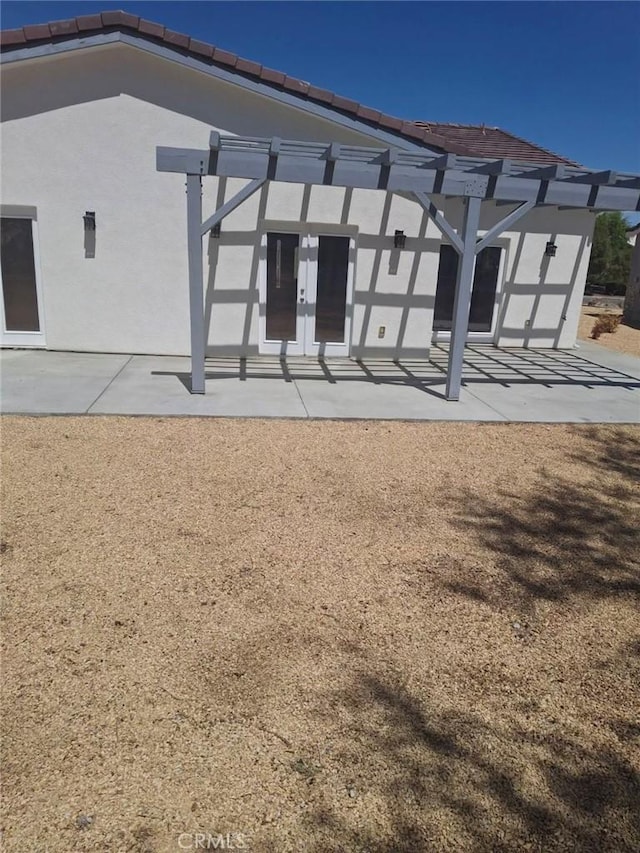 rear view of property with french doors and a patio area