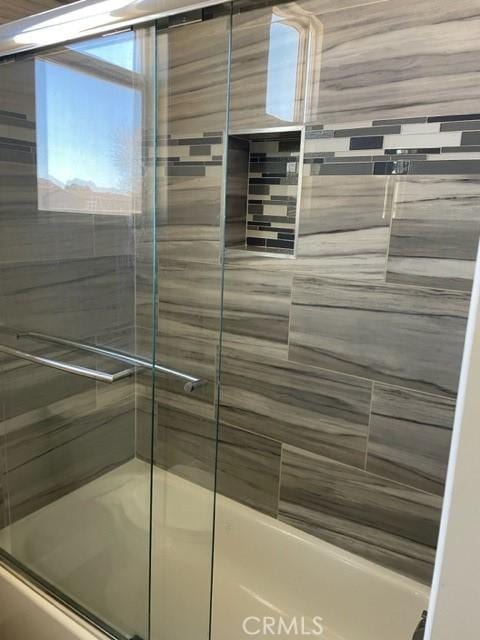 bathroom with shower / bath combination with glass door