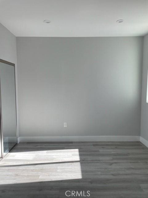 unfurnished room with dark wood-type flooring