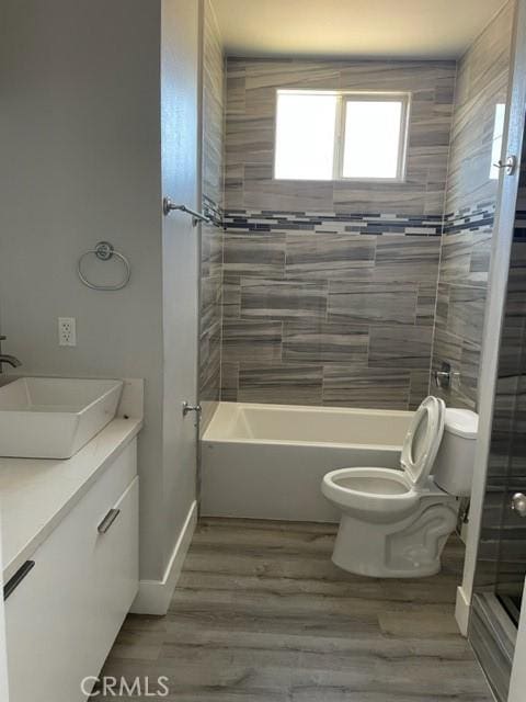 full bathroom with vanity, toilet, wood-type flooring, and tiled shower / bath combo