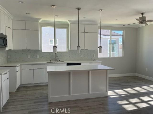 kitchen featuring a center island, white cabinetry, and sink