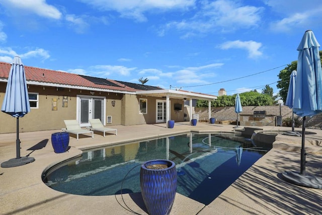 view of pool featuring an in ground hot tub, a patio, and french doors