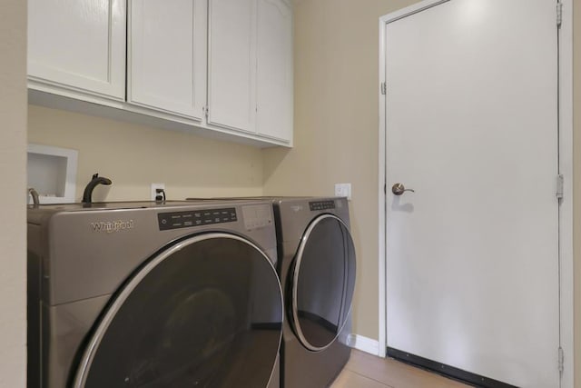 washroom with cabinets and washing machine and clothes dryer