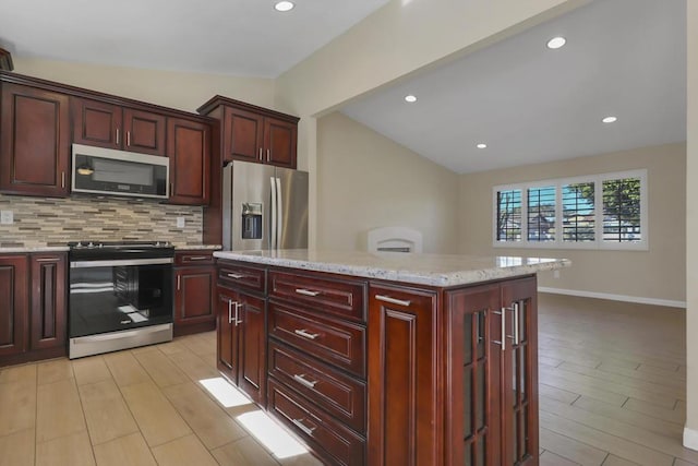 kitchen featuring backsplash, a center island, lofted ceiling, and stainless steel appliances