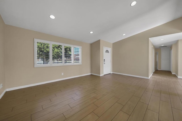 unfurnished room with light hardwood / wood-style flooring and vaulted ceiling