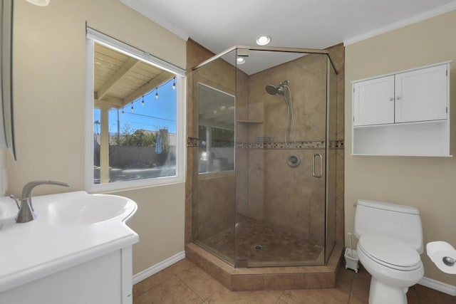 bathroom with tile patterned floors, vanity, crown molding, toilet, and a shower with shower door