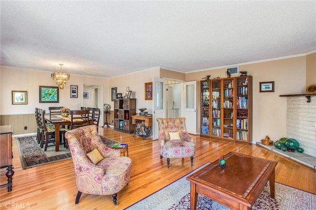 living room with a chandelier, a textured ceiling, and light wood-type flooring