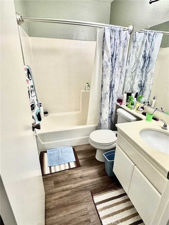 full bathroom with vanity, hardwood / wood-style floors, shower / bathtub combination with curtain, and toilet