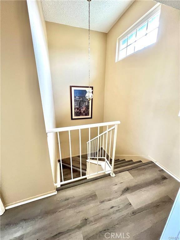 stairway featuring hardwood / wood-style flooring and a textured ceiling