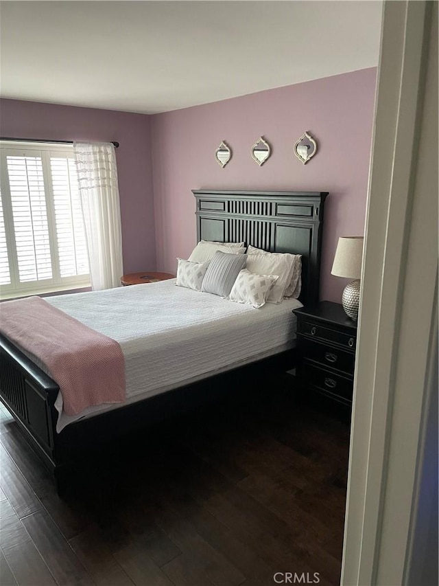 bedroom with dark hardwood / wood-style flooring