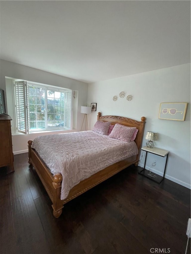 bedroom with dark hardwood / wood-style flooring