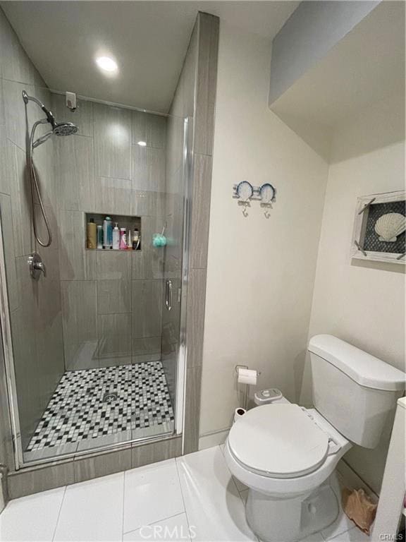 bathroom with tile patterned floors, toilet, and a shower with door