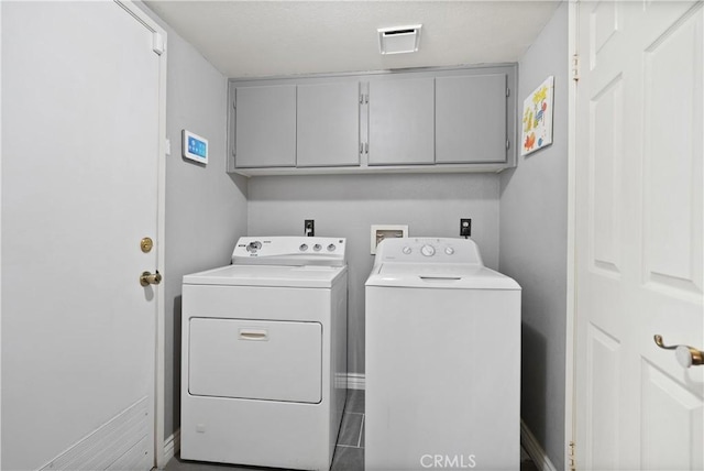 washroom featuring washer and dryer and cabinets