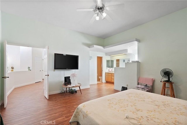 bedroom featuring ensuite bath, ceiling fan, and hardwood / wood-style flooring