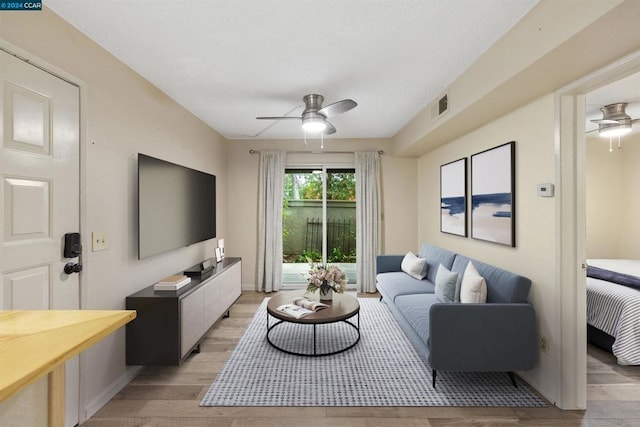 living room with light wood-type flooring and ceiling fan