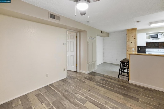 interior space with ceiling fan, wood-type flooring, and a textured ceiling