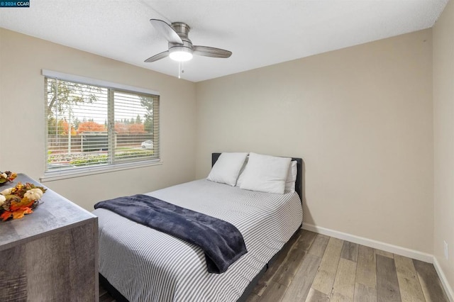 bedroom with ceiling fan and dark wood-type flooring