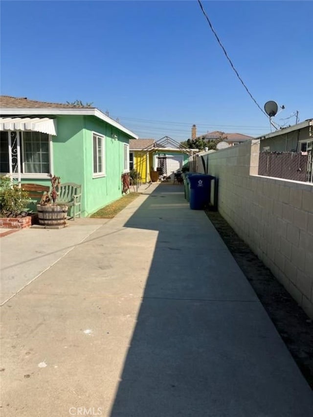 view of side of property with concrete driveway and fence