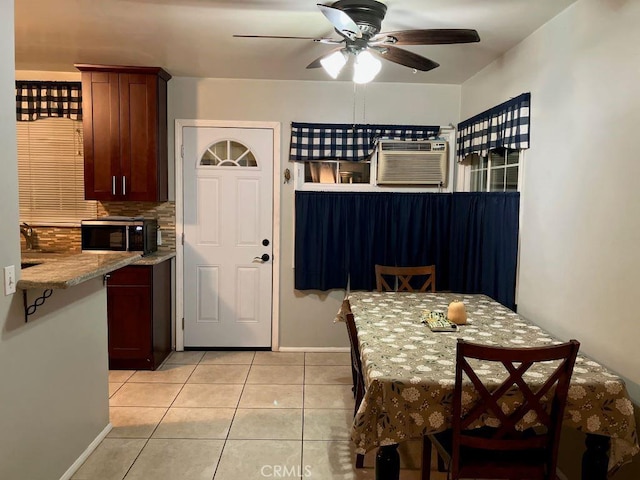 kitchen featuring a ceiling fan, a wall unit AC, light tile patterned flooring, decorative backsplash, and baseboards