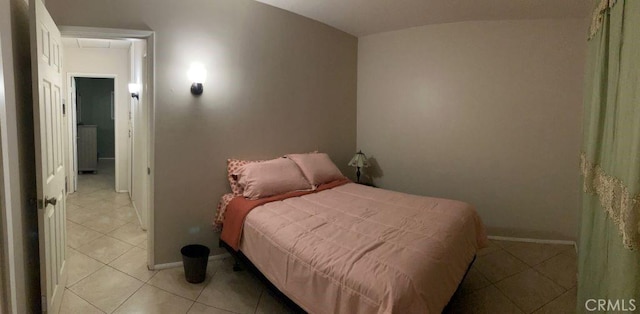 bedroom with light tile patterned floors and baseboards