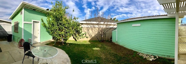 view of yard featuring a fenced backyard, a patio area, a storage unit, and an outdoor structure