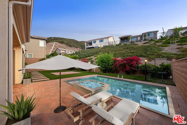 view of pool with an in ground hot tub and a patio