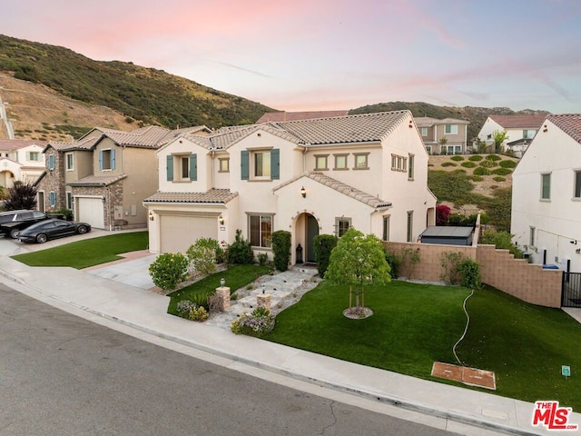 mediterranean / spanish home with a mountain view, a yard, and a garage