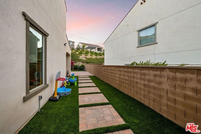 yard at dusk featuring a patio