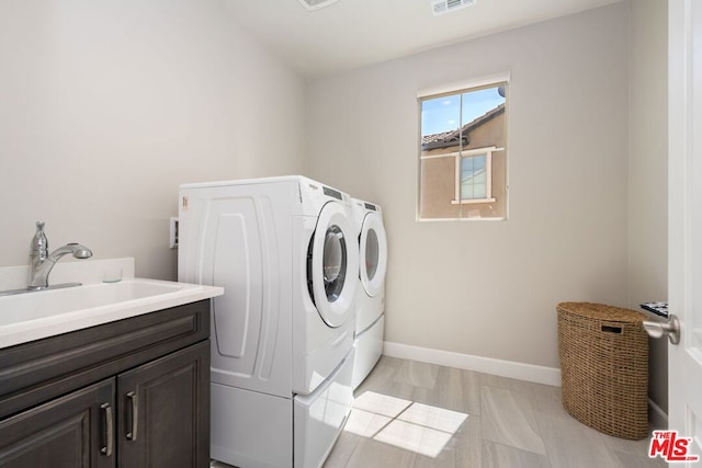 laundry area with cabinets, sink, and washing machine and clothes dryer