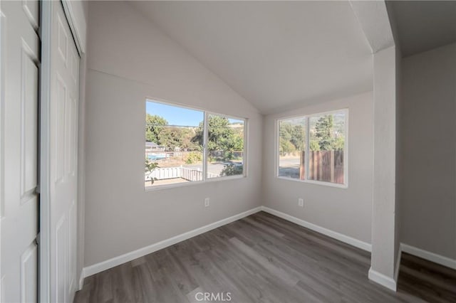 spare room with vaulted ceiling and hardwood / wood-style flooring