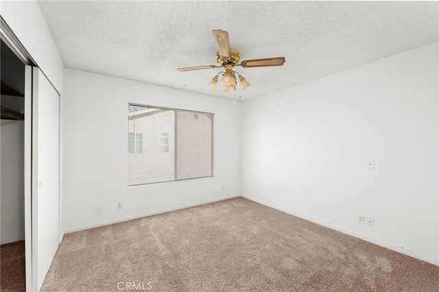 unfurnished bedroom with a textured ceiling, ceiling fan, a closet, and carpet