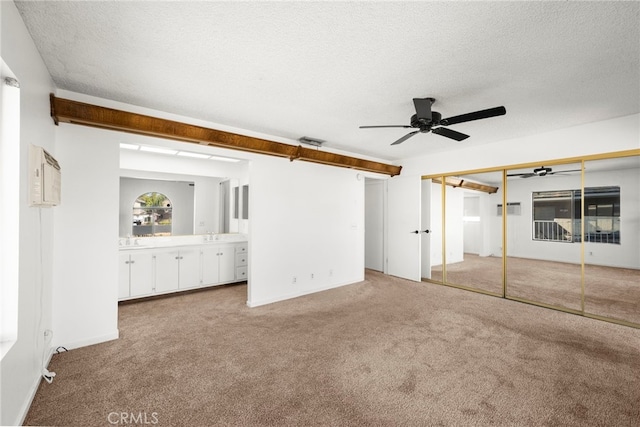 unfurnished bedroom featuring carpet floors, a sink, visible vents, and a textured ceiling