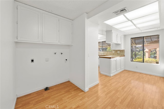 clothes washing area featuring cabinet space, baseboards, light wood-style floors, washer hookup, and electric dryer hookup