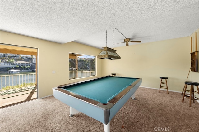 recreation room featuring carpet, baseboards, and a textured ceiling