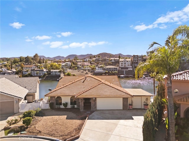 mediterranean / spanish house featuring a water and mountain view and a garage