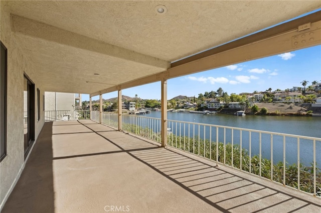 view of patio with a water view and a balcony