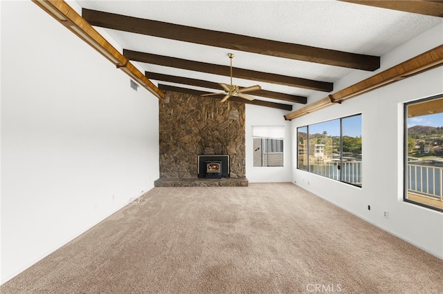 unfurnished living room with a textured ceiling, ceiling fan, lofted ceiling with beams, visible vents, and carpet