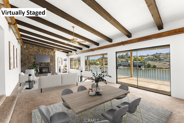 carpeted living area with vaulted ceiling with beams, ceiling fan, a fireplace, and a textured ceiling