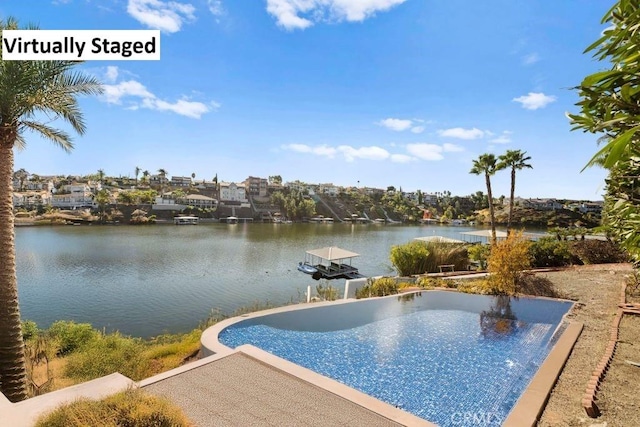 view of swimming pool featuring a water view and a boat dock