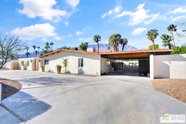 view of front facade with a carport and a mountain view