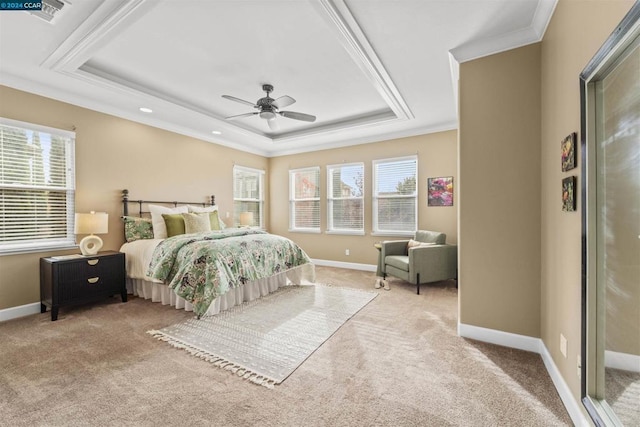 carpeted bedroom featuring multiple windows, a raised ceiling, ceiling fan, and ornamental molding