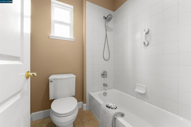 bathroom with tile patterned flooring, tiled shower / bath combo, and toilet